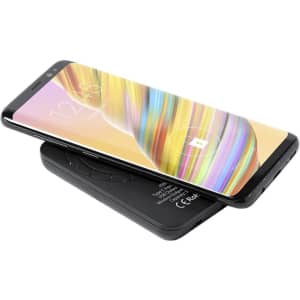 A black power bank with a smartphone on top, displaying a colourful screen and featuring a logo.