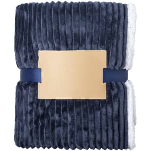 A navy blue fleece blanket with a textured ribbed pattern, folded and secured with a band, featuring a logo.