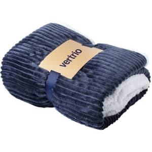 A folded navy blue blanket with a soft, white underside and a logo tag.