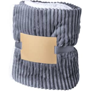 A grey Karovix blanket, featuring a plush texture and a smooth band for storage, with a logo on the band.