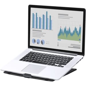 A laptop on a black stand displaying graphs and charts on the screen. The device is silver with a black keyboard.