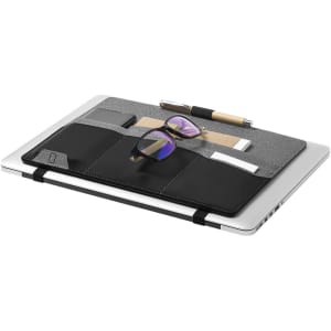A sleek organiser with a grey fabric top, black leather pockets, glasses, and stationery on a laptop.