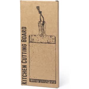A wooden kitchen cutting board in a cardboard packaging, featuring a hanging rope detail. The product has a rustic design.