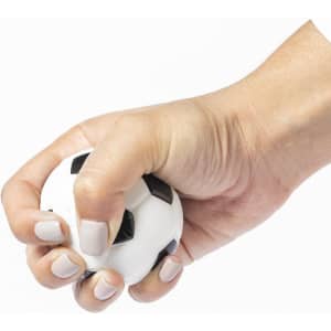 A white stress ball shaped like a soccer ball, held tightly in a hand with light-coloured nails.