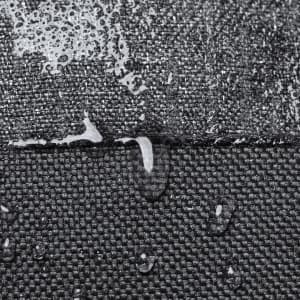 Close-up of water droplets on a textured black fabric, showcasing its water-resistant properties.
