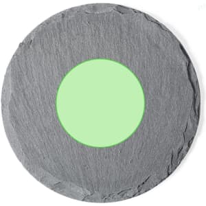 A slate coaster with a circular green centre, designed for home use, featuring a textured grey surface.