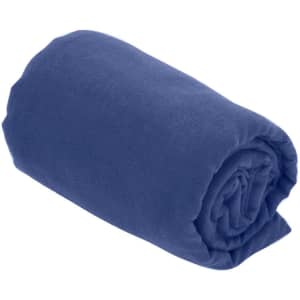A rolled-up bath towel in deep blue fabric, featuring a logo on one side.
