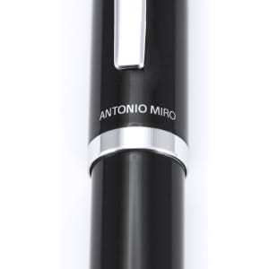 A black metal pen with a silver clip and branding. The pen features a sleek, modern design.