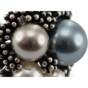 A close-up of a Pleus Adjustable Ring featuring various pearls in silver and blue hues, set within a textured black design.