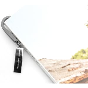 A silver bookmark attached to a grey book, displaying a branding logo.