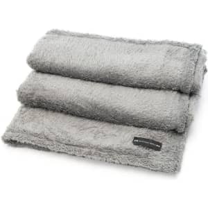 A soft grey blanket folded neatly, featuring a small logo on one edge. Ideal for home comfort and warmth.