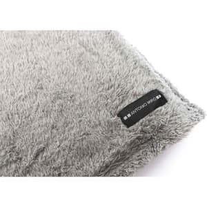 A soft, grey Kira blanket with a textured surface and a small logo tag.