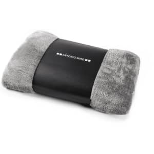 A grey plush blanket with a smooth black band featuring a logo. Soft and cozy design for comfortable living.