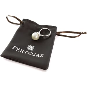 An adjustable ring featuring a pearl, displayed alongside a drawstring pouch with a logo.