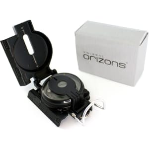 A black compass with a clear lens and a box. The compass features measurement markings and has a branding logo.