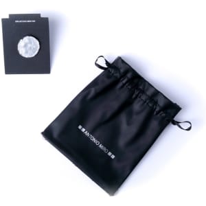 A black drawstring pouch with a logo, containing a silver adjustable ring and a card.