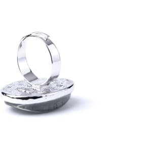 A silver adjustable ring with a textured circular base, set against a plain white background.