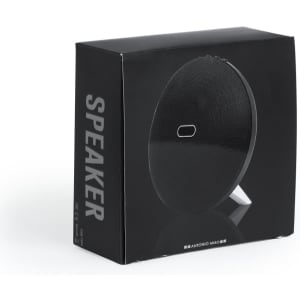 A black speaker packaged in a box with a simple design and a logo. The box features a stand on the back.