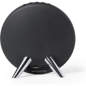A round black speaker with silver legs and various ports on the back. It features a logo.