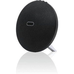 A round black speaker with a mesh surface and a stand, featuring a simple logo on the front.