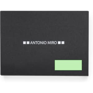 A sleek black notebook with a logo; features a green label on the lower right corner.