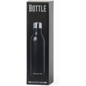 A drink bottle in sleek black with a silver cap, presented in a stylish black box featuring branding.