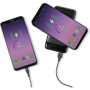 Two smartphones charging wirelessly, with one phone connected via USB cable. Both devices display battery charge indicators.