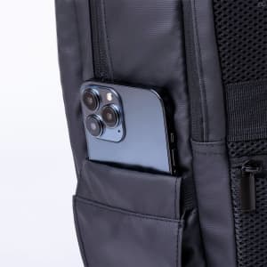 A black backpack featuring a side pocket with a smartphone tucked inside. The fabric appears durable and textured.