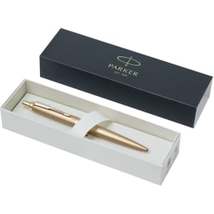 A metal pen in a gold finish situated in a gift box with a logo. The box is black with a white interior.