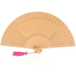 A decorative Madera hand fan in light brown with intricate cut-out designs and a pink tassel.