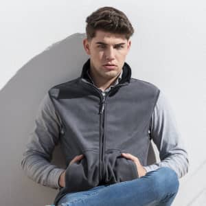 A grey polar fleece jacket with a zippered front, worn by a young man against a light background.