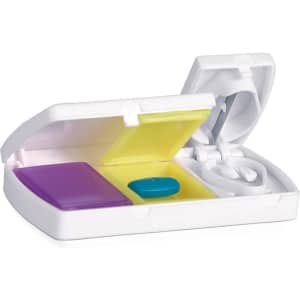 A pillbox in white includes compartments in yellow and purple, with a blue pill and a small white tablet.