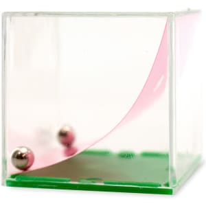 A transparent cube with a green base and a pink curved surface, featuring two metal balls inside.
