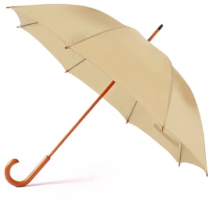 A beige umbrella with a wooden handle and a curved tip, featuring a logo on the canopy.