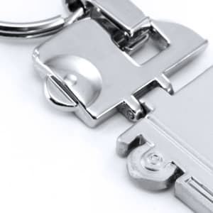 A silver trailer keyring with a metallic finish, featuring a detailed design and a keyring attachment.