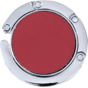 A round, foldable bag hanger in shiny silver and deep red, featuring a simple design and a logo.
