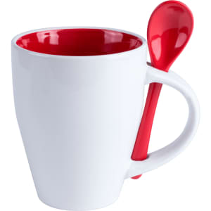 A white mug with a red interior and a matching red spoon attached to the handle.