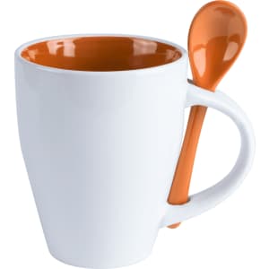 A white coffee mug with an orange interior and an orange spoon attached to the side. The mug has a modern design.