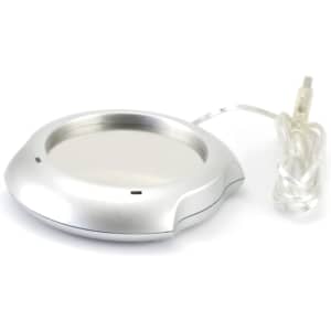 A silver mug warmer with a circular design and a connected power cord. It features a sleek, modern look.