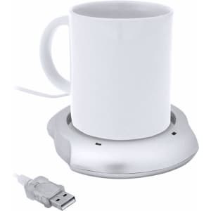 A white mug on a silver cup warmer with a USB cable connected, designed for keeping beverages warm.