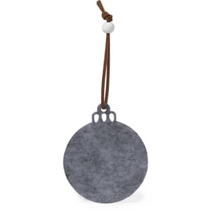 A grey circular tag with a leather string and bead attachment. It features a decorative cut-out design at the top.