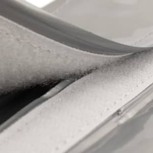 A drink bottle cooler featuring a grey exterior with a velcro closure and a soft inner lining.