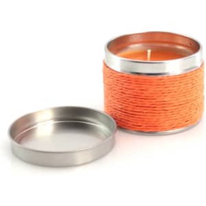 An orange aromatic candle in a metal tin with a removable lid, featuring a woven texture on the exterior.