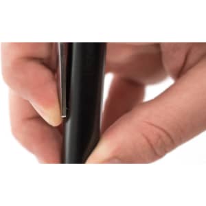 A black keyring torch being held by a hand, showcasing its sleek design and functionality.