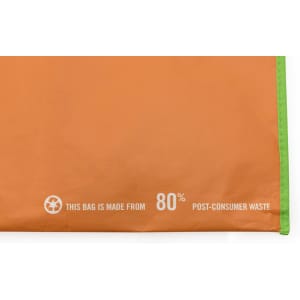 An orange tote bag with a green trim, featuring a logo and information about its post-consumer waste material.