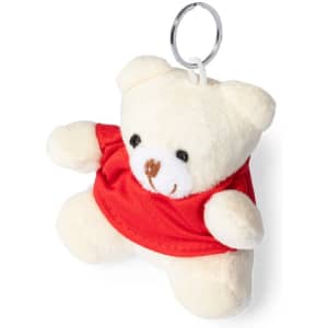 A cream teddy bear keyring wearing a red shirt, with a metal keyring attached. It has a small, friendly face.