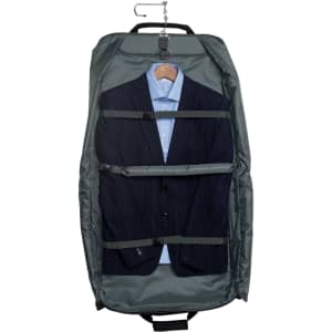 A green Transporter Garment Bag containing a formal suit and a blue shirt on a hanger. Features a logo.