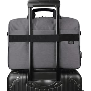 A grey laptop bag with a handle and strap, placed on top of a black suitcase. The bag has a logo.