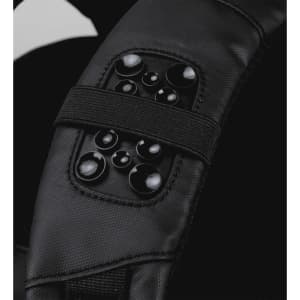 A close-up of a black backpack strap featuring a textured panel with multiple circular buttons.