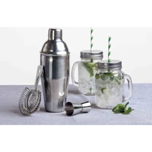 A stainless steel cocktail shaker, a strainer, a jigger, and two glass jars with green straws and mint garnish.